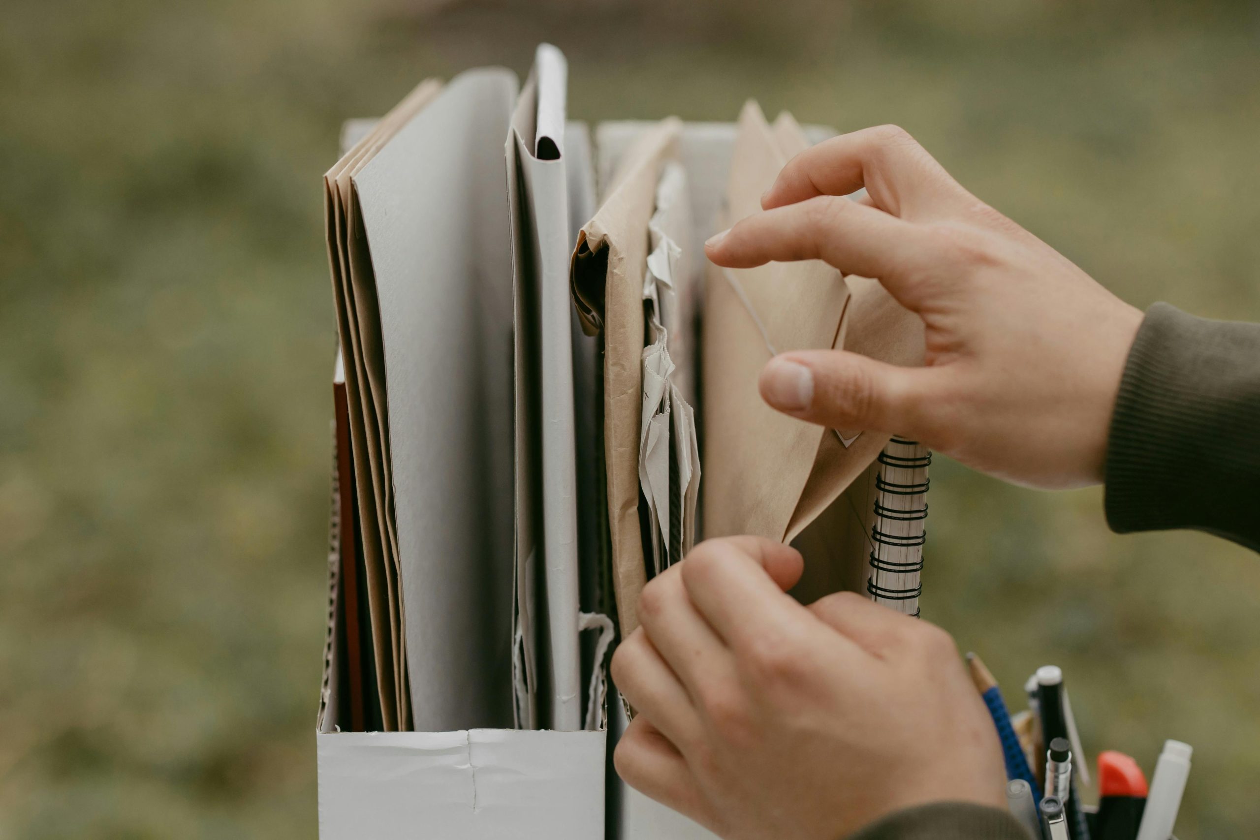 pexels photo 6636326 6636326 Hands organizing documents and envelopes, emphasizing office work and organization outdoors.